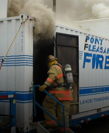 A firefighter entering the smoke-filled Point Pleasant Fire flashover training simulator