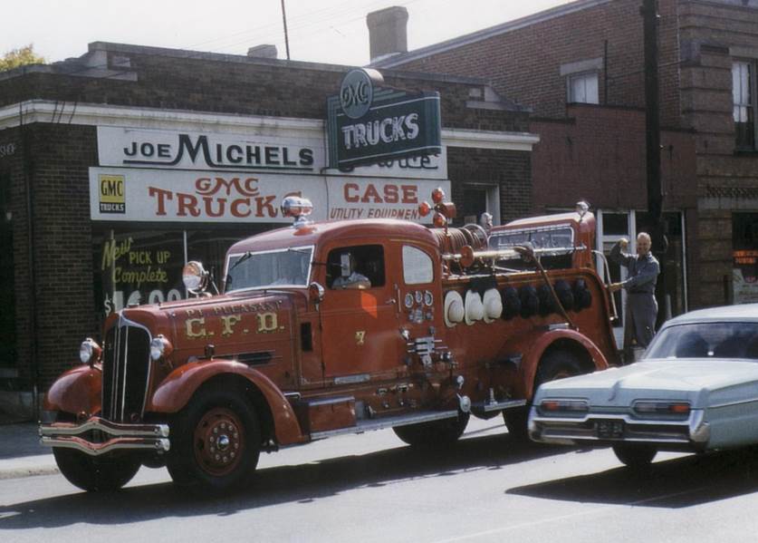 An early red pumper on the street outside Joe Michels GMC Trucks